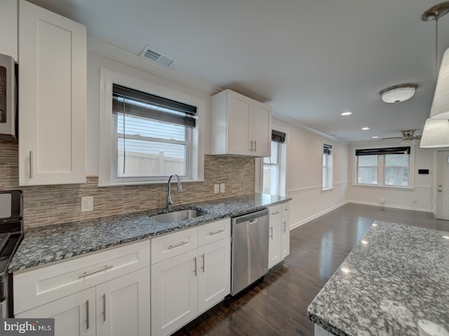 kitchen featuring sink, dishwasher, white cabinets, decorative backsplash, and dark stone counters