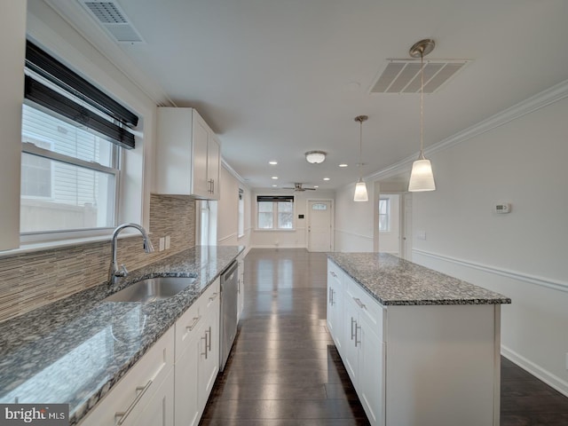 kitchen featuring white cabinetry, sink, a center island, and dishwasher