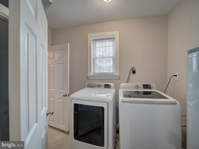 clothes washing area with water heater and washer and clothes dryer