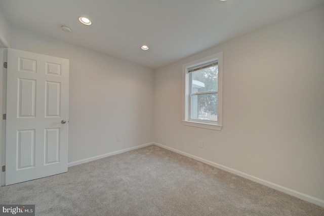 unfurnished room with light colored carpet