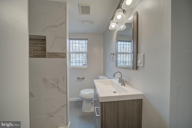 bathroom with vanity, a wealth of natural light, toilet, and a tile shower