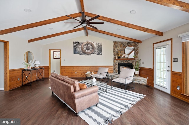 living room featuring a stone fireplace, dark hardwood / wood-style floors, wooden walls, lofted ceiling with beams, and ceiling fan