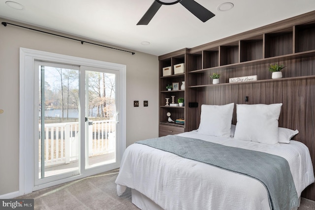 carpeted bedroom featuring a water view, access to outside, and ceiling fan