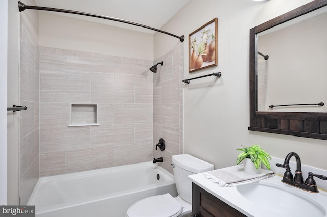 full bathroom with vanity, tiled shower / bath combo, and toilet