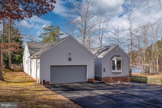 view of front of property featuring a garage and a water view