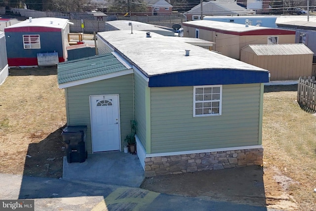 view of front of property featuring fence and an outbuilding