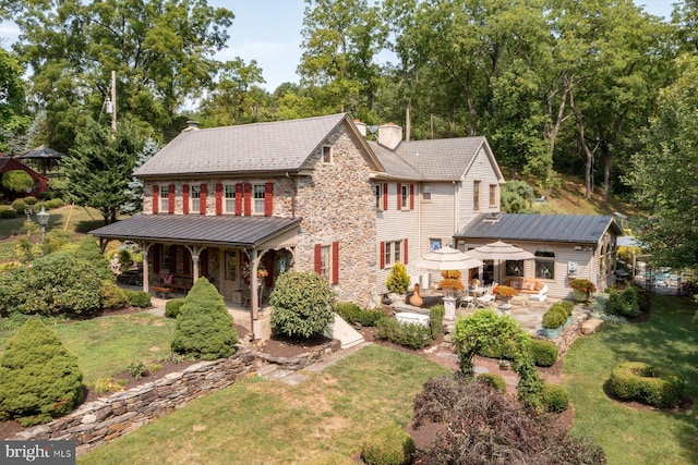 back of property with a patio area and a lawn