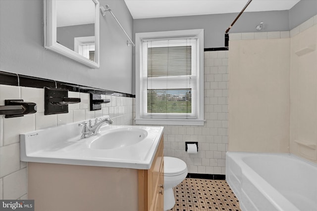 full bathroom featuring vanity, toilet, tub / shower combination, and tile walls