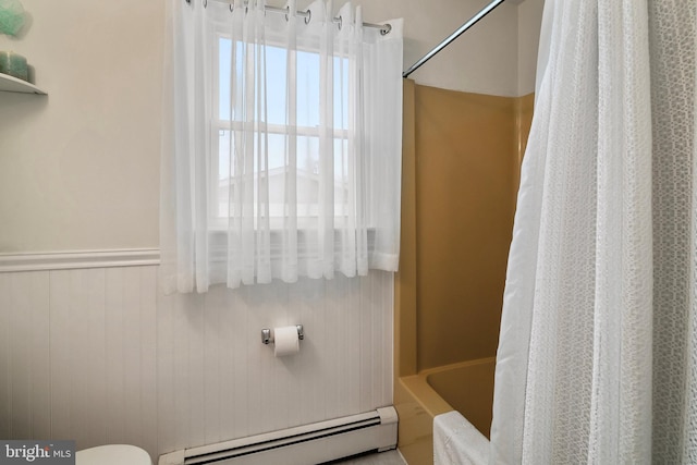 bathroom with a baseboard radiator, toilet, and shower / bath combo with shower curtain