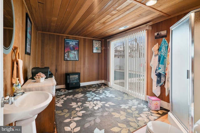 bathroom featuring an enclosed shower, sink, wooden ceiling, and wood walls