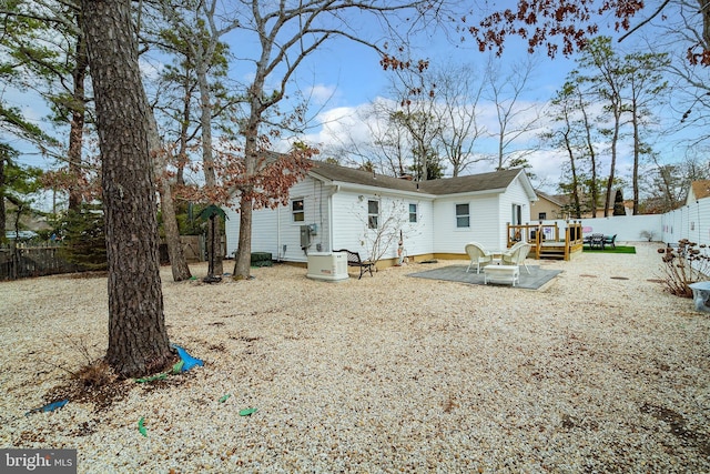 rear view of property with a wooden deck and a patio area