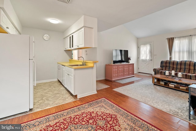 kitchen featuring sink, white cabinets, white appliances, and light hardwood / wood-style floors