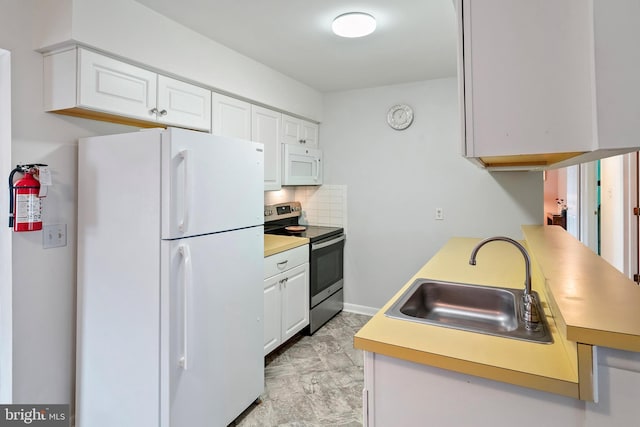 kitchen featuring tasteful backsplash, white cabinetry, sink, and white appliances