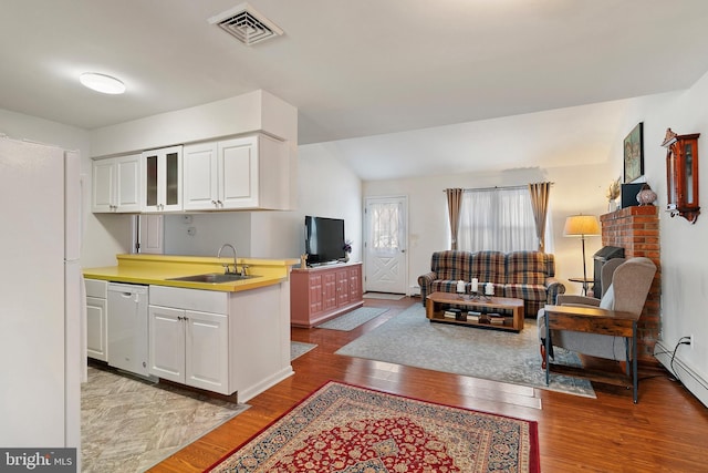 kitchen with lofted ceiling, sink, white cabinetry, white appliances, and light hardwood / wood-style floors