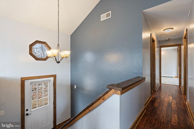 hallway featuring dark wood-type flooring, a chandelier, and a baseboard heating unit