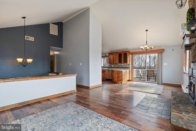 kitchen with an inviting chandelier, dark hardwood / wood-style floors, high vaulted ceiling, and backsplash