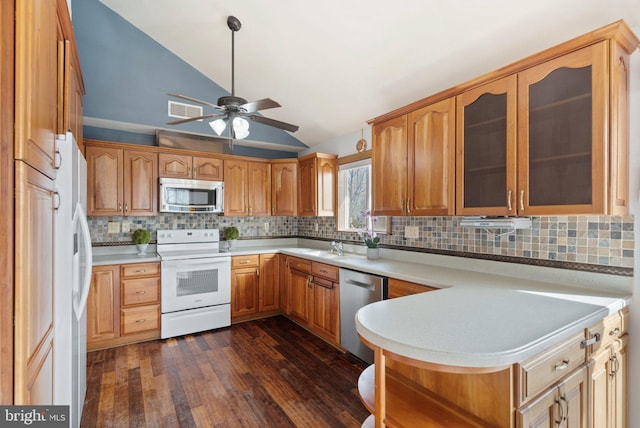 kitchen featuring vaulted ceiling, appliances with stainless steel finishes, dark wood-type flooring, and decorative backsplash