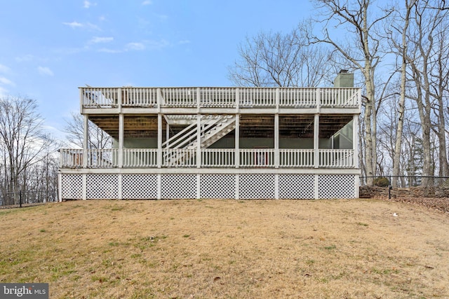 rear view of house with a wooden deck and a yard