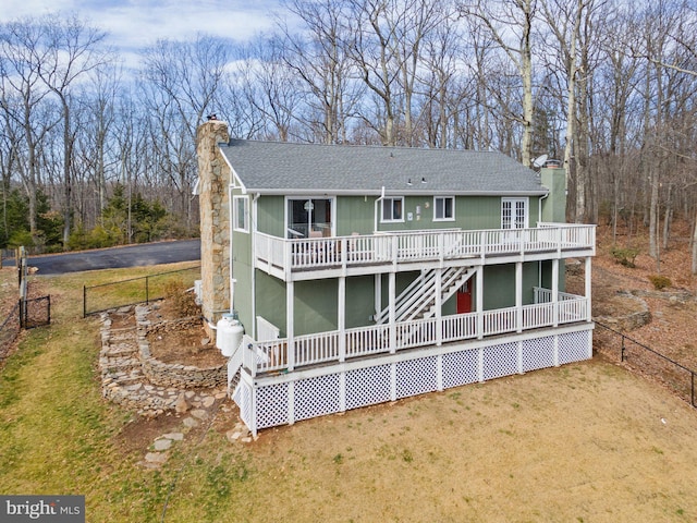 view of front of house with a deck and a front yard