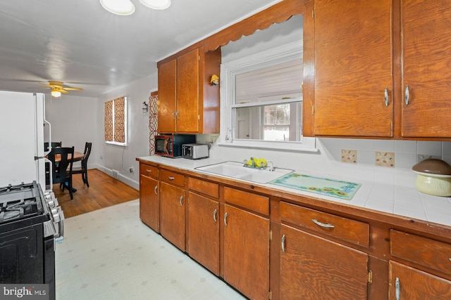 kitchen with ceiling fan, white refrigerator, sink, and gas range