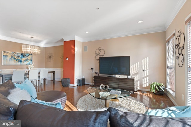 living room with ornamental molding, dark wood-type flooring, and an inviting chandelier