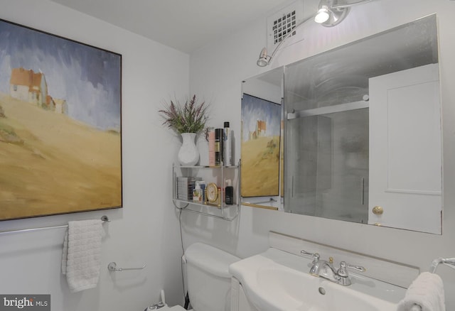 full bath featuring a shower with door, visible vents, toilet, and a sink