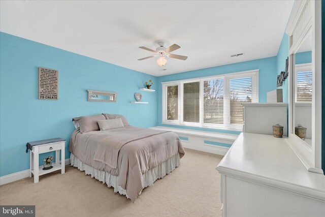 bedroom with visible vents, multiple windows, light colored carpet, and baseboards