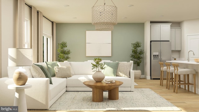 living room featuring an inviting chandelier, sink, and light wood-type flooring