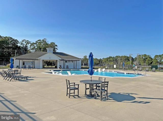 view of pool featuring a patio and an outbuilding