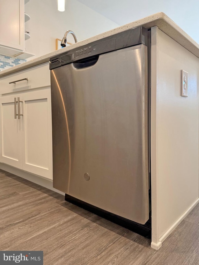 interior details with white cabinetry, dishwasher, and light hardwood / wood-style flooring