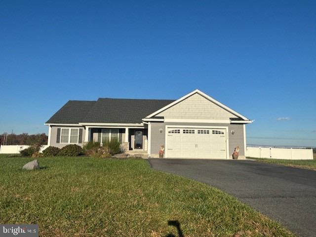 ranch-style house featuring a garage and a front lawn