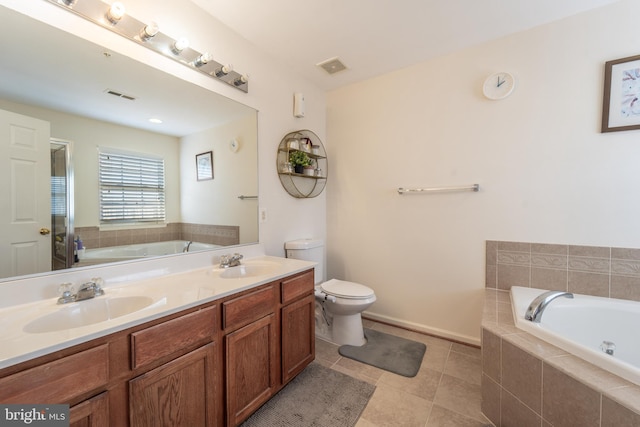 bathroom with vanity, toilet, tile patterned flooring, and tiled tub