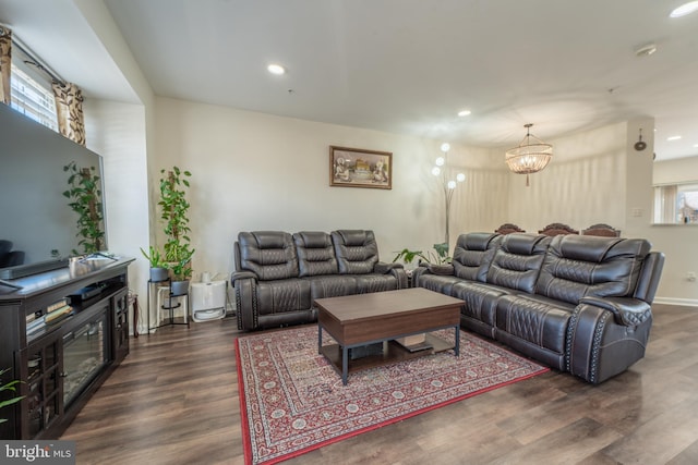 living room with dark hardwood / wood-style flooring and a notable chandelier