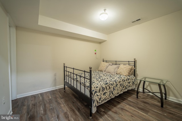 bedroom with dark hardwood / wood-style flooring