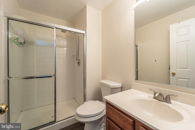 bathroom with toilet, vanity, and walk in shower