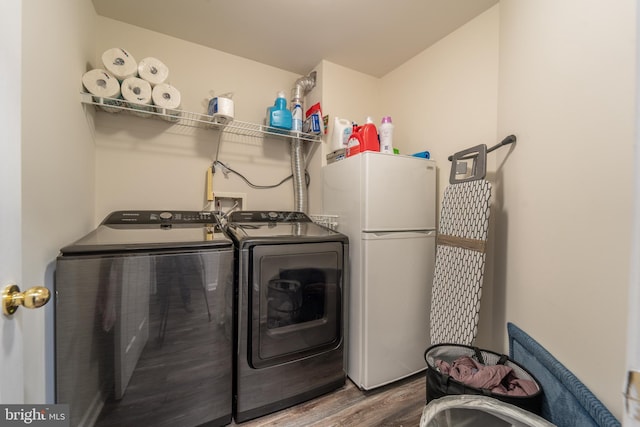 laundry room featuring hardwood / wood-style flooring and washing machine and clothes dryer