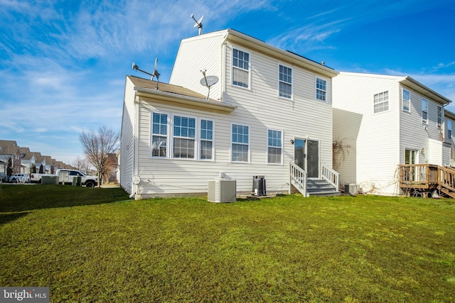 back of house featuring a yard and central air condition unit