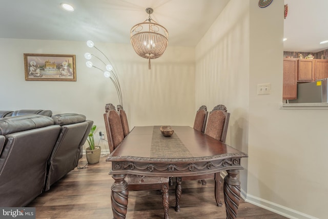 dining space featuring dark hardwood / wood-style flooring and an inviting chandelier