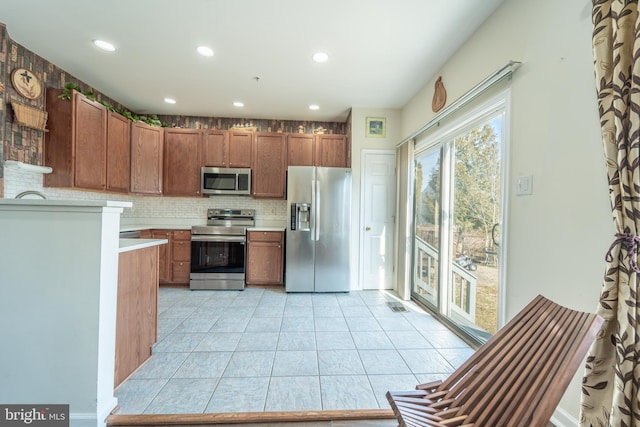 kitchen featuring tasteful backsplash, light tile patterned floors, and stainless steel appliances