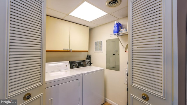 clothes washing area featuring electric panel, cabinets, and washing machine and dryer