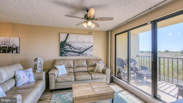 living room featuring a textured ceiling, light hardwood / wood-style flooring, and ceiling fan