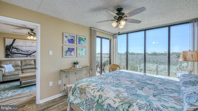 bedroom with hardwood / wood-style flooring, ceiling fan, floor to ceiling windows, and a textured ceiling