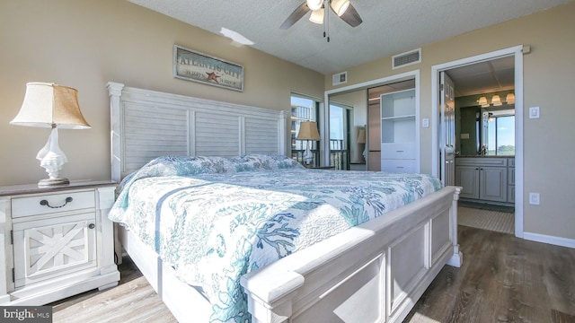 bedroom featuring connected bathroom, a textured ceiling, a closet, hardwood / wood-style flooring, and ceiling fan