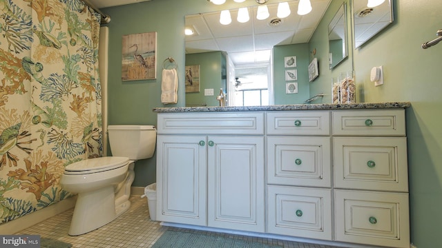 bathroom featuring vanity, a paneled ceiling, tile patterned floors, and toilet