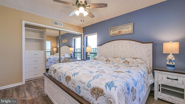 bedroom with ceiling fan, dark wood-type flooring, a closet, and a textured ceiling