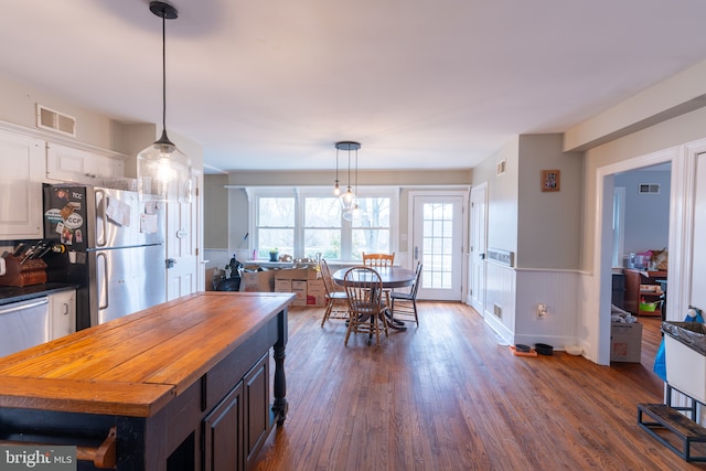 kitchen featuring white cabinetry, pendant lighting, dark wood-type flooring, and appliances with stainless steel finishes