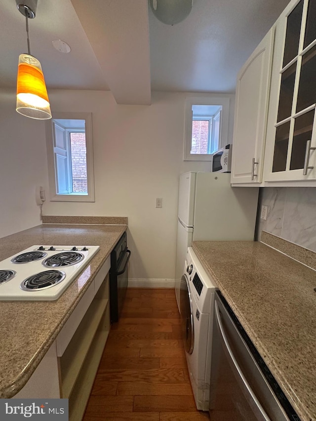 kitchen with pendant lighting, washer / dryer, white cabinets, dark wood-type flooring, and white appliances