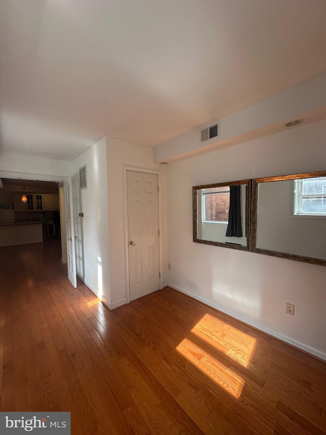 unfurnished room with hardwood / wood-style flooring