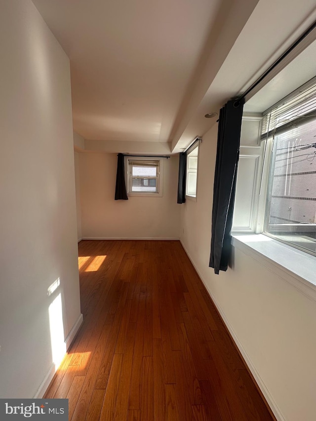 corridor with hardwood / wood-style floors