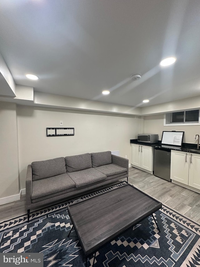 living room with sink and light hardwood / wood-style flooring